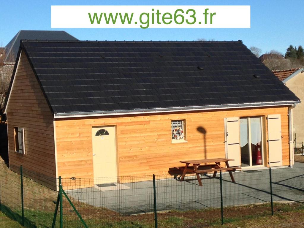 een kleine schuur met een picknicktafel ervoor bij Le chalet des Patures in Rochefort-Montagne