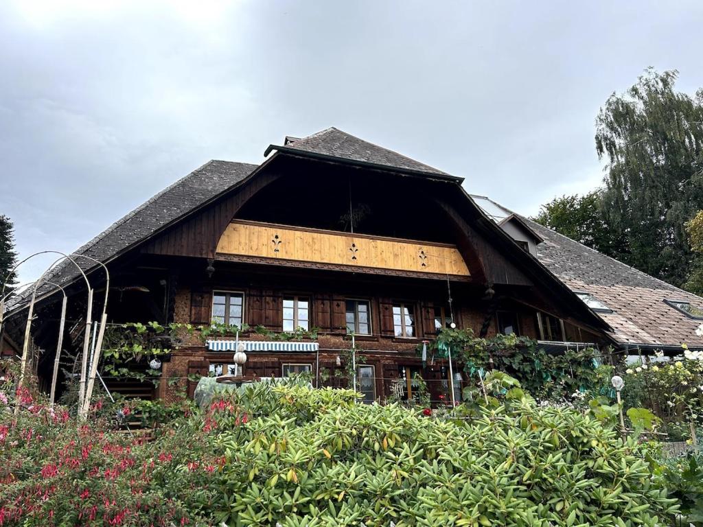 una grande casa di legno con un grande tetto di Familienferien in einem 200 Jahre alten Berner Bauernhaus 