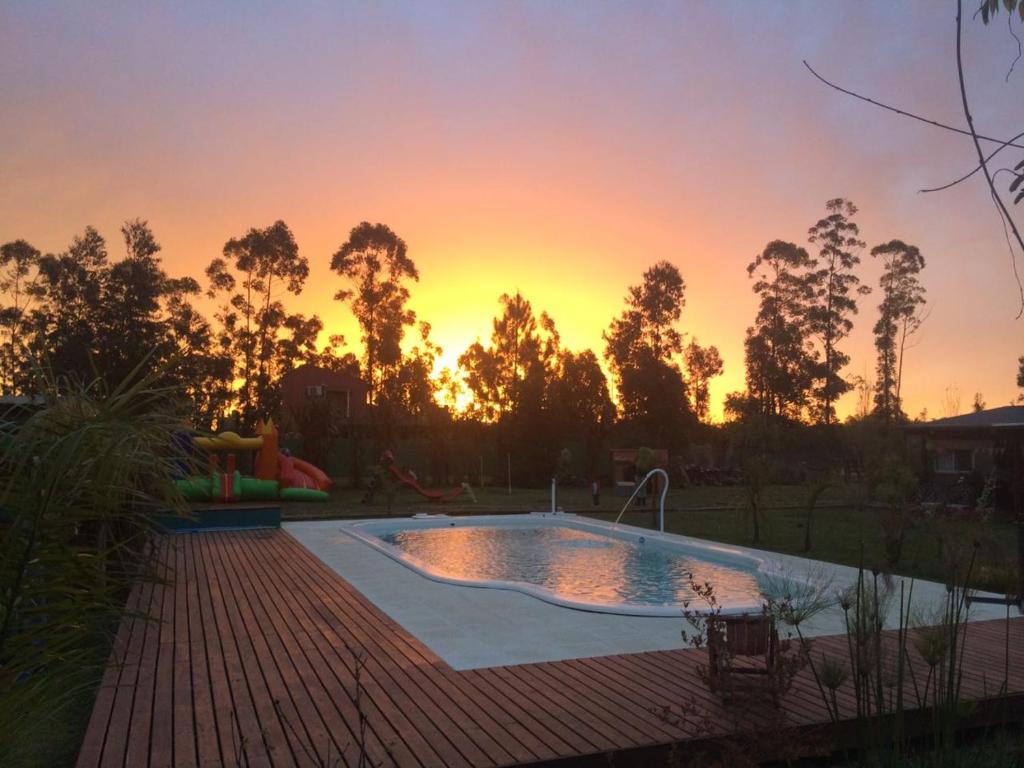 una piscina con tramonto sullo sfondo di Aratiri Cabañas, Un Lugar En El Bosque.. a Colón