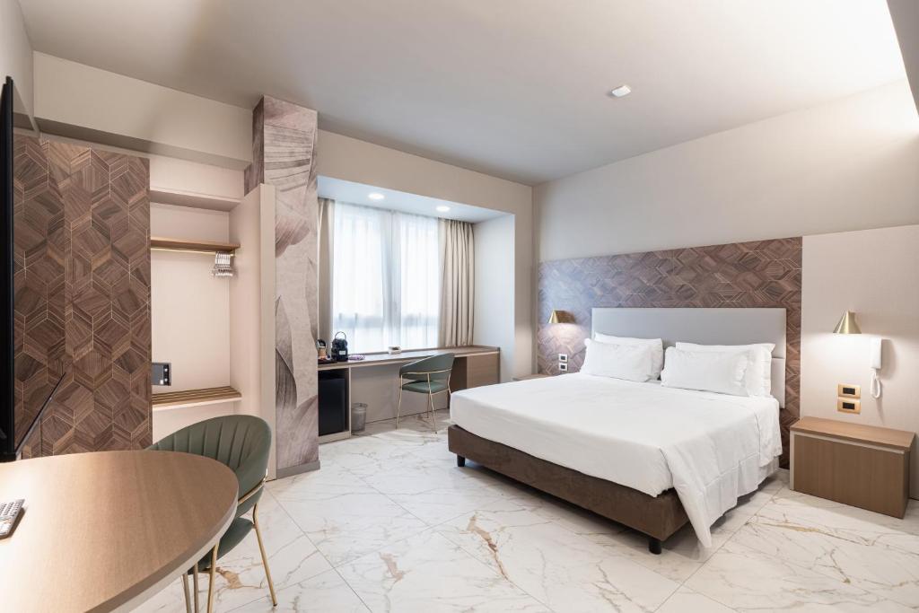 a hotel room with a bed and a desk at Baires Guest House in Milan