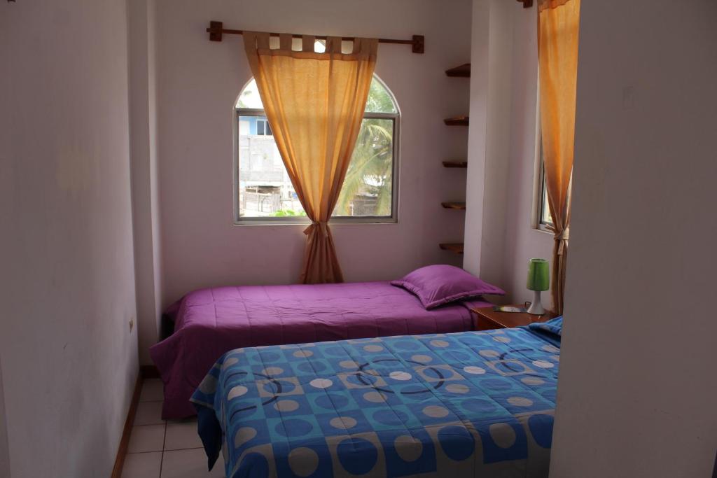 1 dormitorio con 2 camas y ventana en The Finch House (La Casa del Pinzón) en Puerto Ayora