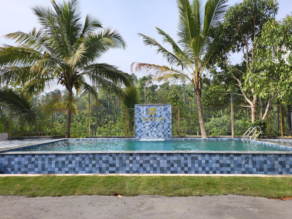 een zwembad met een fontein voor palmbomen bij Rainy Cloud Homestay Private Cottages -Pool, Estate, Near to Falls & Safari in Chikmagalūr