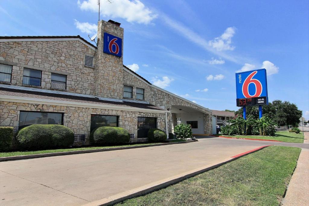 un edificio con una señal delante de él en Motel 6 Austin, TX - Central Downtown UT, en Austin
