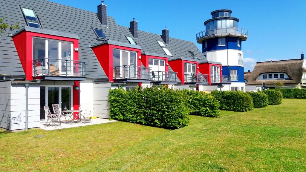a red and white house with a lighthouse at Deichhaus Boddentraum in Breege