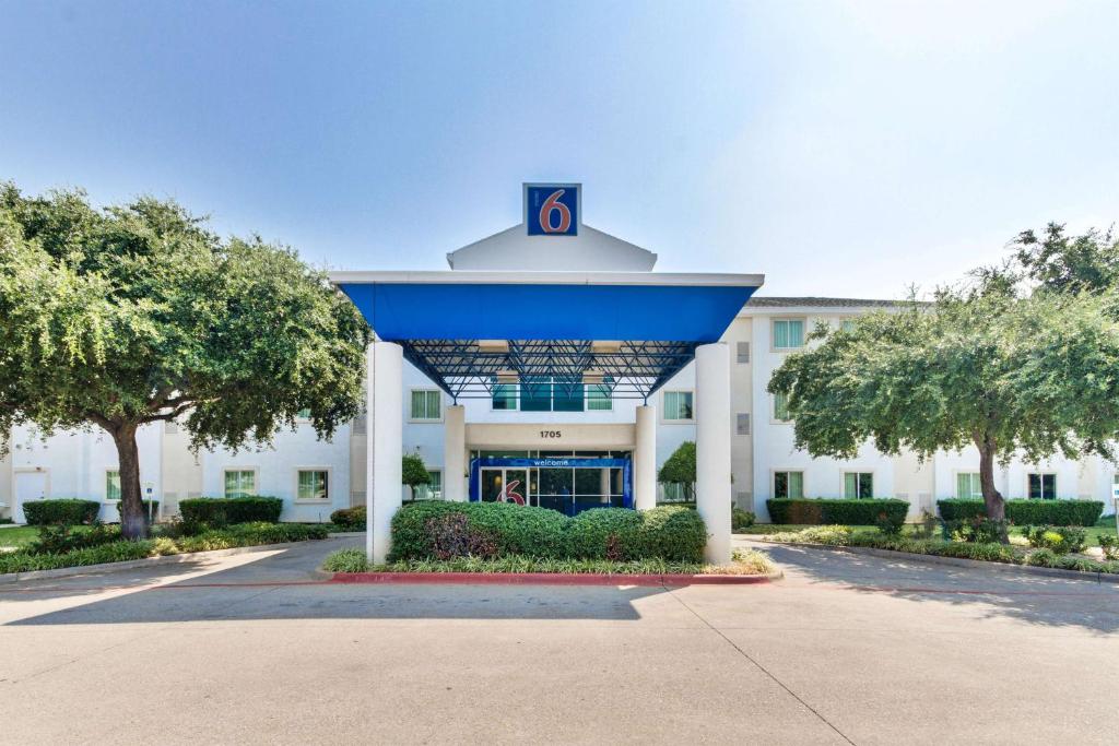 un grand bâtiment blanc avec un toit bleu dans l'établissement Motel 6-Lewisville, TX - Dallas, à Lewisville