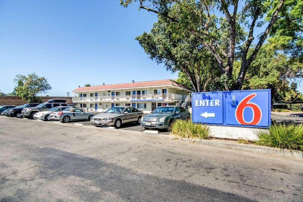 a parking lot with a sign in front of a building at Motel 6-Stockton, CA - North in Lincoln Village