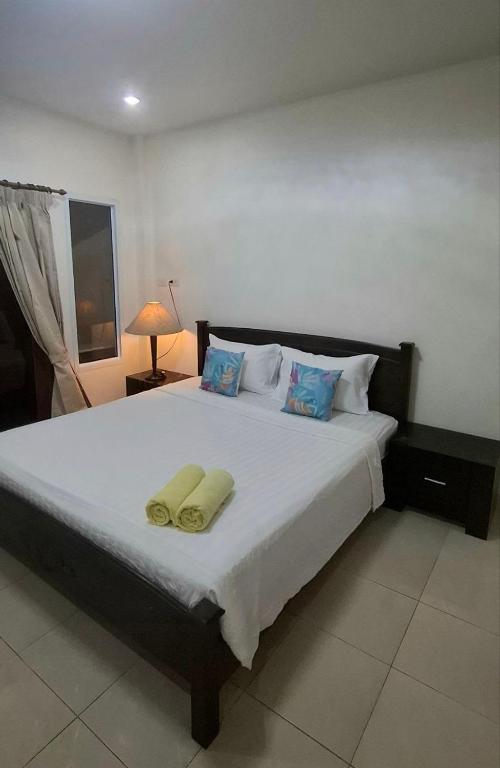 a bedroom with a large bed with two yellow pillows at Pharos Apartments in Nathon Bay
