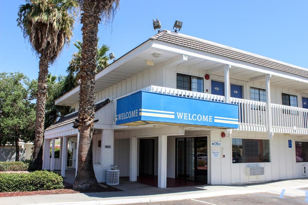 un edificio con un cartel azul de bienvenida en Motel 6-Coalinga, CA - East en Coalinga