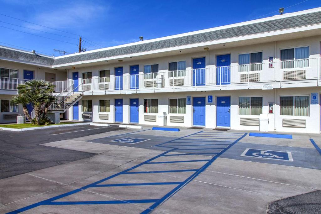 um edifício com portas azuis e brancas e um parque de estacionamento em Motel 6-Phoenix, AZ - Airport - 24th Street em Phoenix