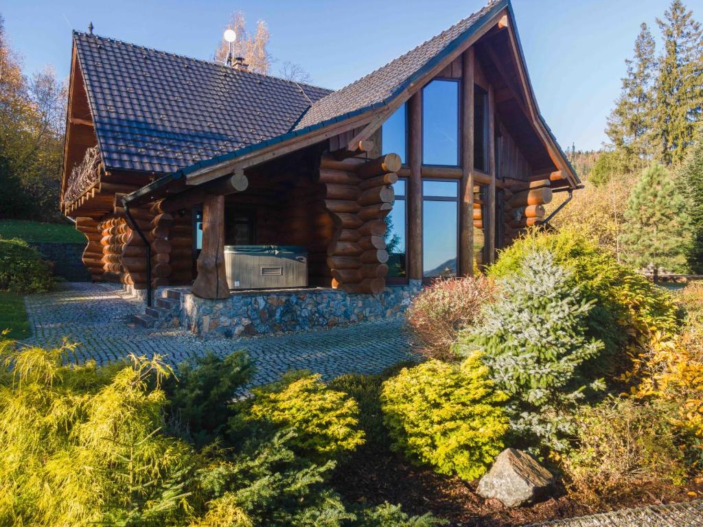 a log cabin with a large window in a garden at Srub Eden in Frýdek-Místek