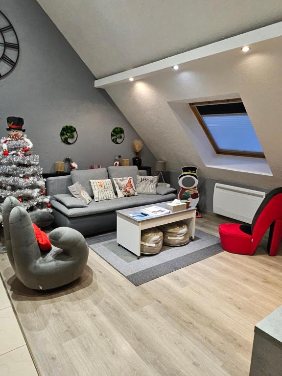 ein Wohnzimmer mit einer Couch und einem Weihnachtsbaum in der Unterkunft Gîte Vallée de Munster 3 étoiles chez Flavie & Ludo in Muhlbach-sur-Munster