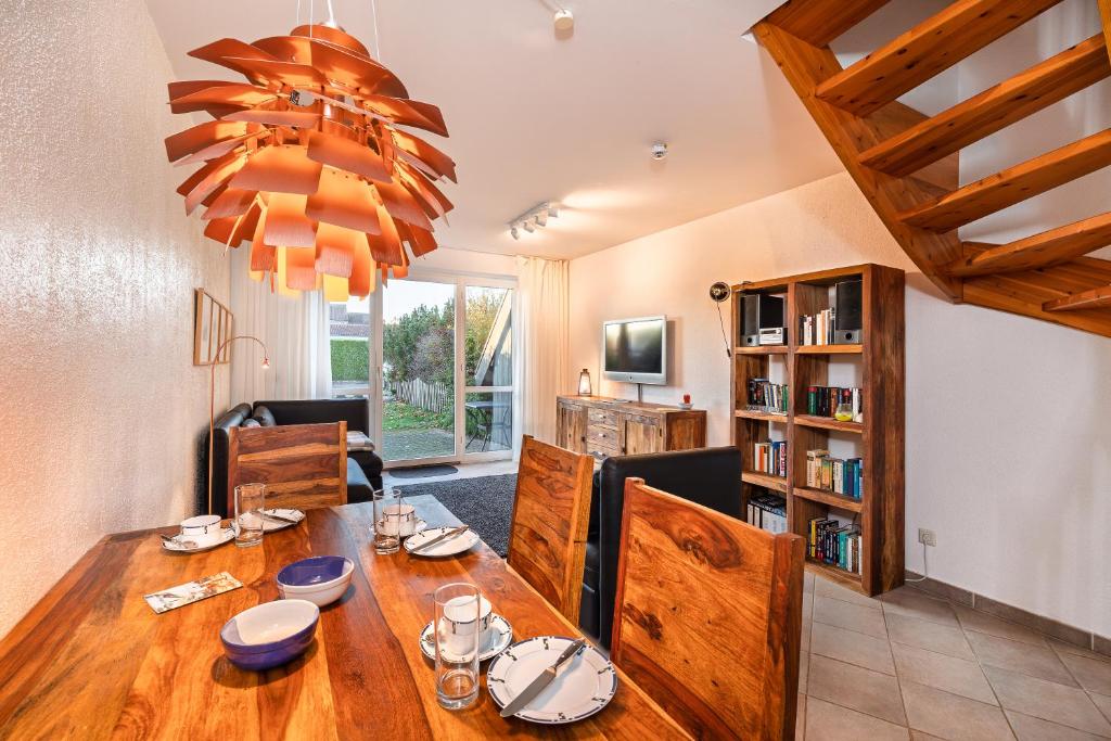 a dining room with a wooden table and a chandelier at Haus Wittow in Breege