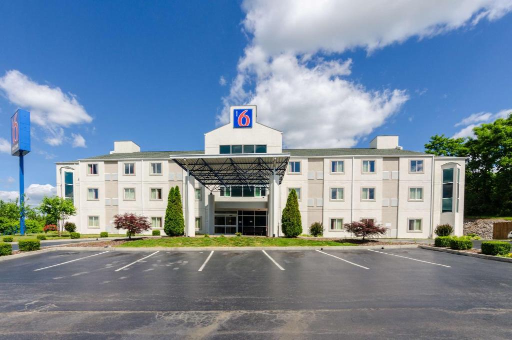 Motel 6-Bristol, VA في بريستول: مبنى أبيض كبير مع موقف للسيارات