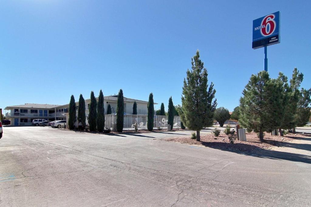 a gas station with a sign on the side of a road at Motel 6-Carlsbad, NM in Carlsbad