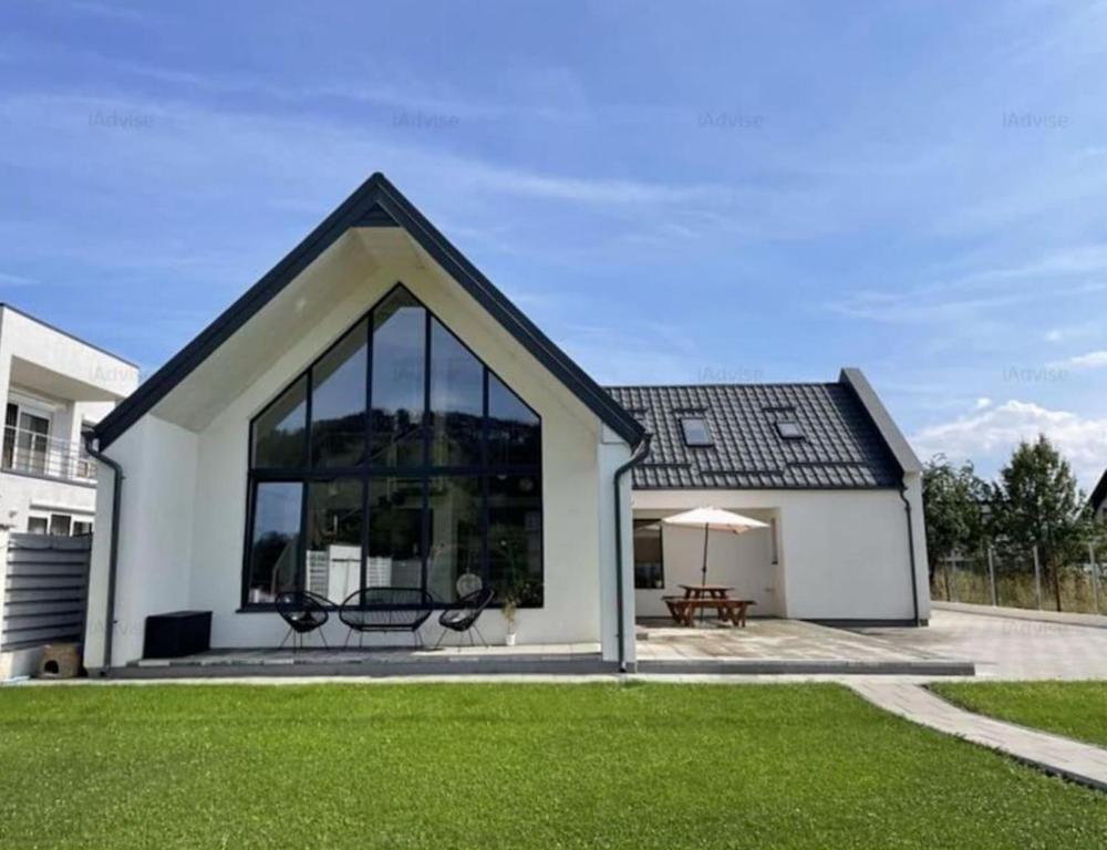 una piccola casa bianca con una grande finestra di Pineview Lempes a Braşov