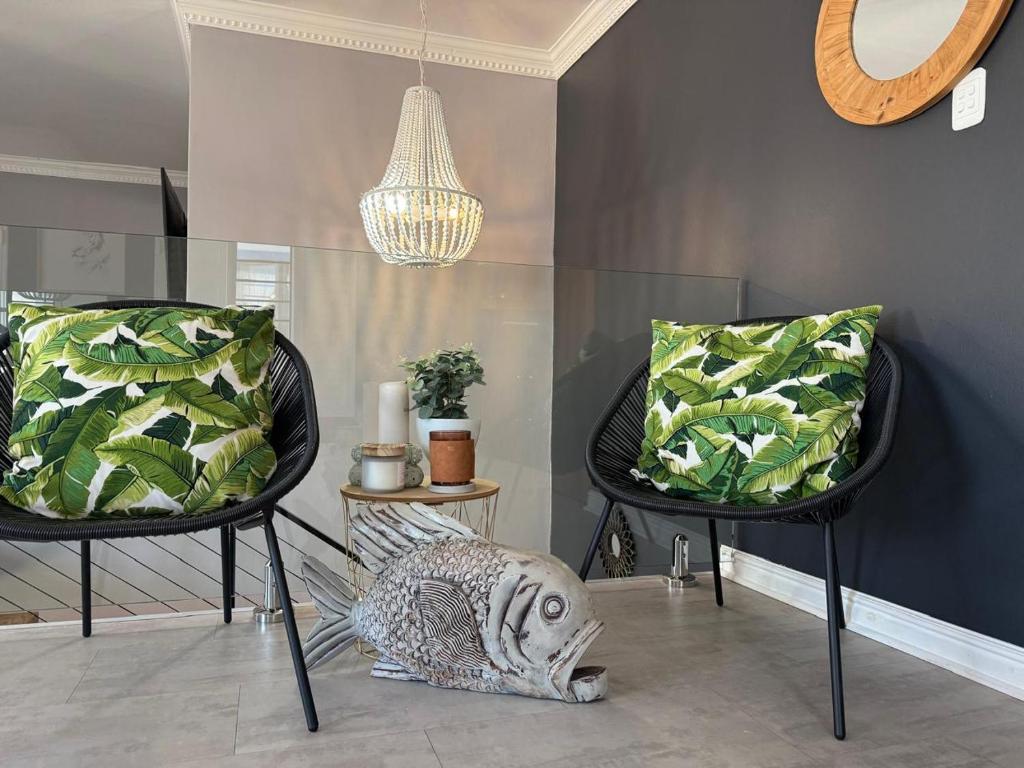 een kamer met 2 stoelen en een kroonluchter bij Casa Mia in Jeffreys Bay