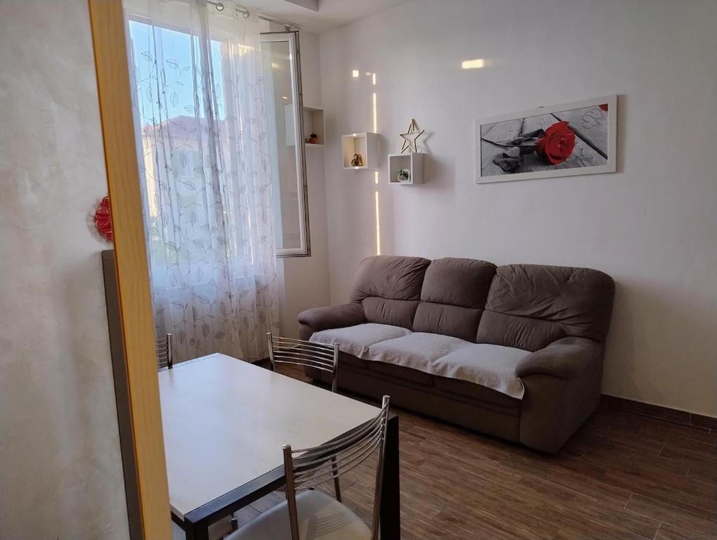 een woonkamer met een bank en een tafel bij Bright and cozy apartment in Sesto San Giovanni