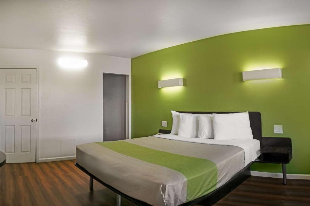 a bedroom with a large bed with a green wall at Motel 6-Visalia, CA in Visalia