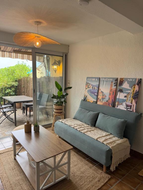 een woonkamer met een blauwe bank en een tafel bij Cozy apartment in Bormes-les-Mimosas