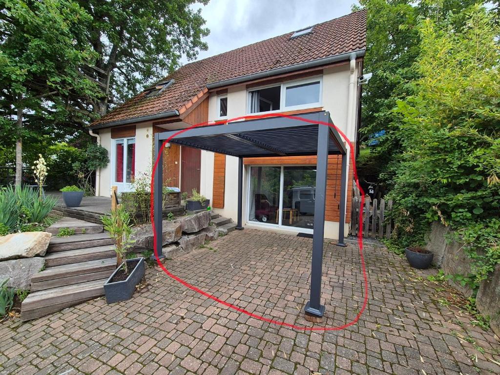 a house with a red hose around a house at Le Loft Des Cigognes in Barr
