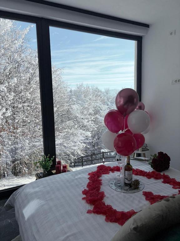a room with a bed with balloons and a window at Tea House Ponoarele in Ponoarele