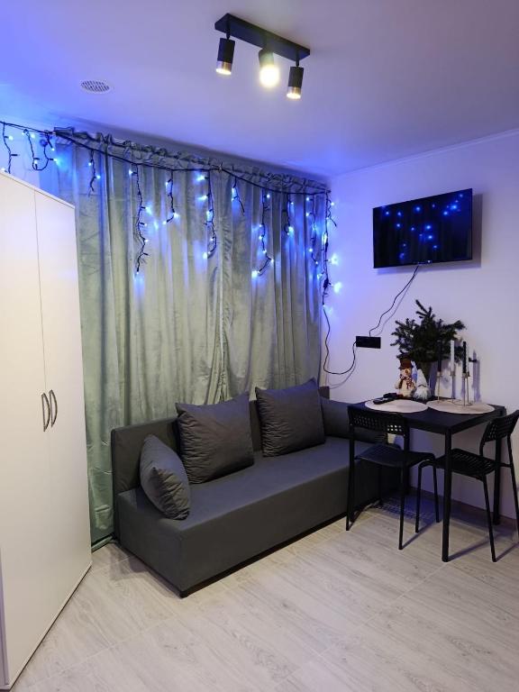 een woonkamer met een bank en een tafel bij Pokoje w Łomiankach Warszawa in Łomianki