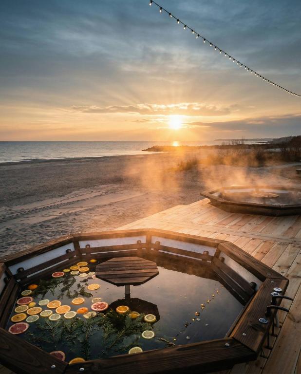 a bath tub on the beach with the sunset in the background at Era Maris in Odesa