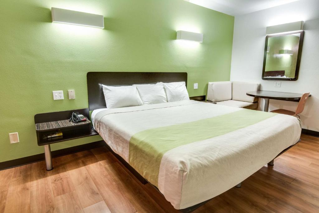 a bedroom with a large bed with a green wall at Motel 6-Longview, TX - North in Longview
