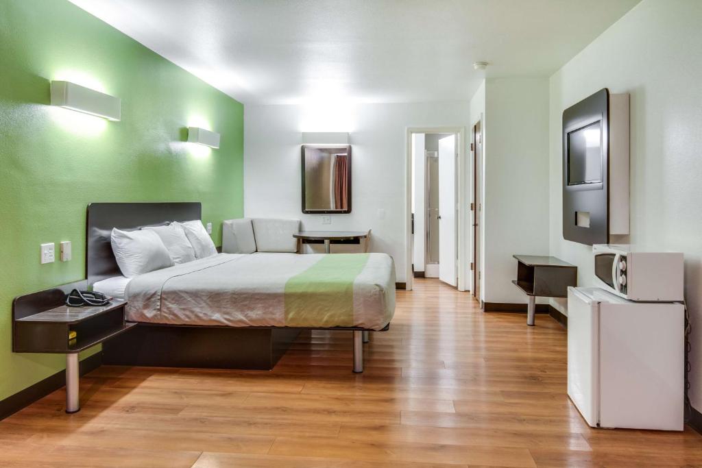 a bedroom with a bed and a green wall at Motel 6-Longview, TX - North in Longview