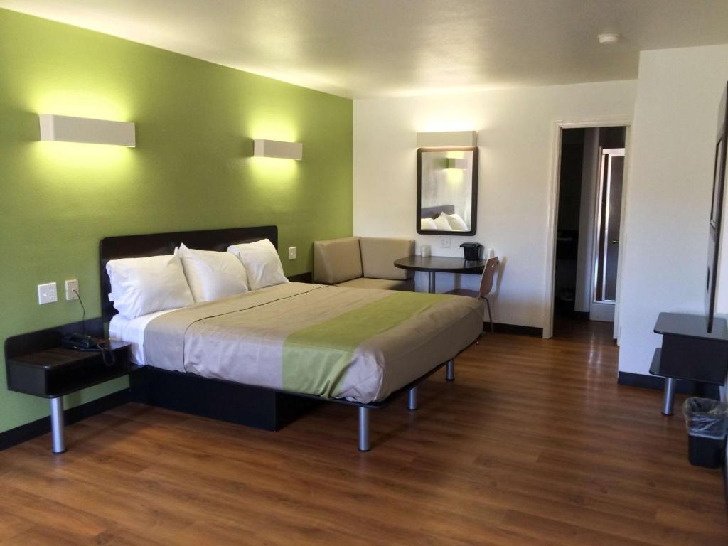 a bedroom with a bed and a green wall at Motel 6-Longview, TX - North in Longview