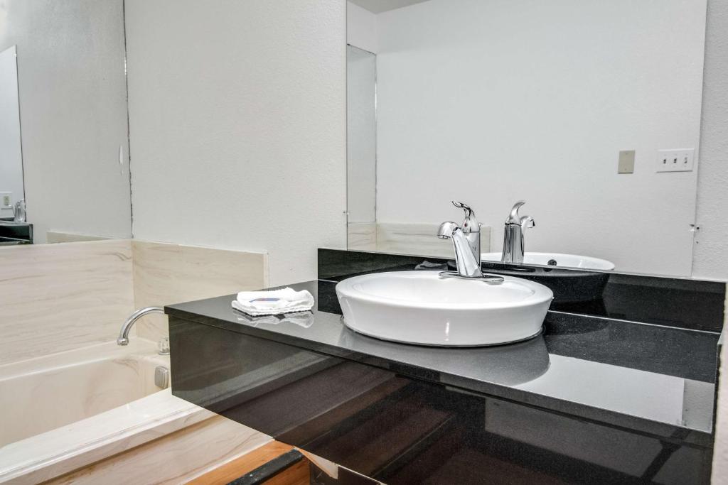 a bathroom with a sink and a bath tub at Motel 6-Longview, TX - North in Longview