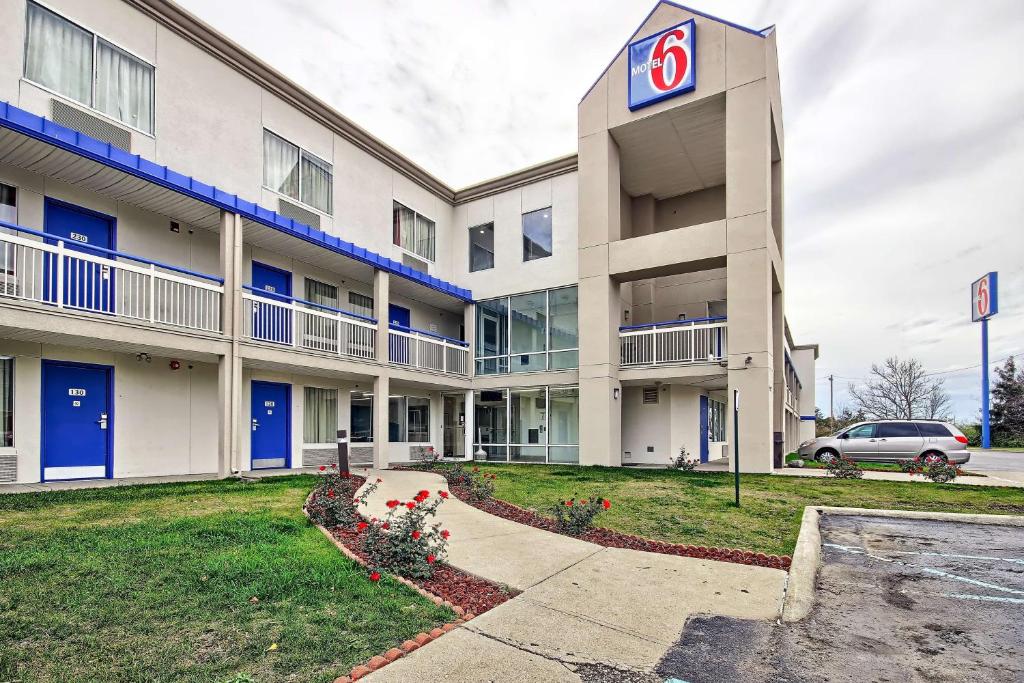 Motel 6-Columbus, OH - West في كولومبوس: مبنى امامه علامة محطة وقود