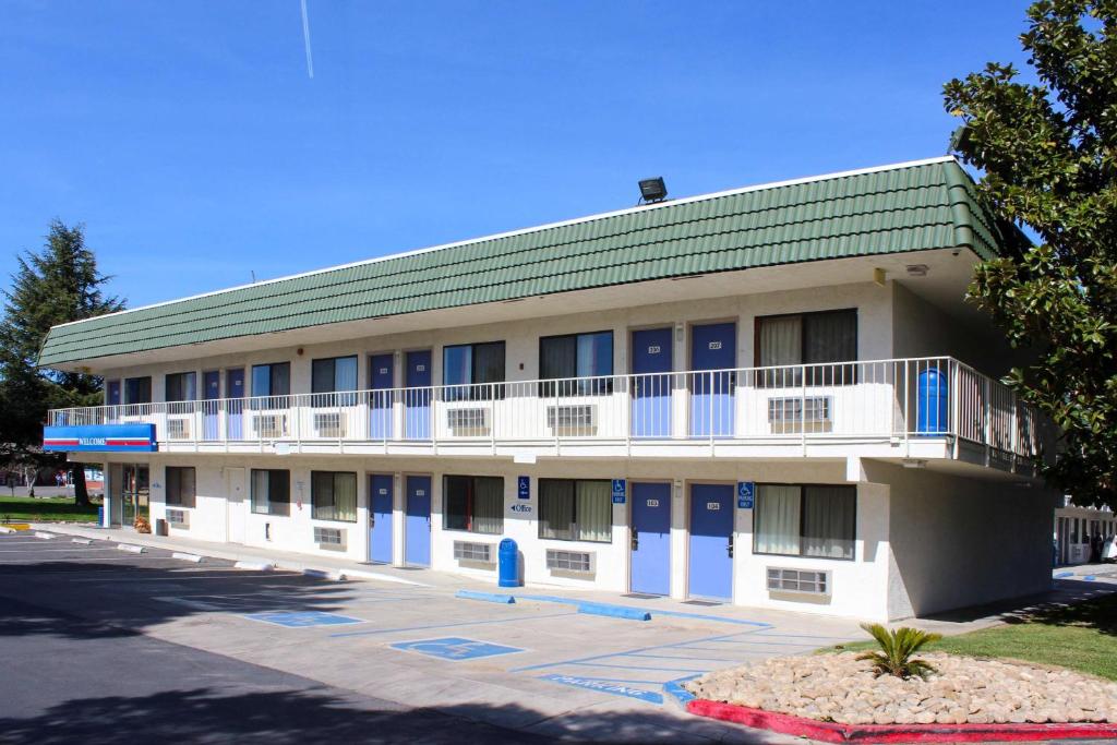 a building with blue doors and a green roof at Motel 6-King City, CA in King City