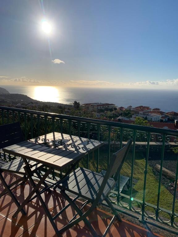 a table and chairs on a balcony with the ocean at Namastê House I in Relógio do Poiso