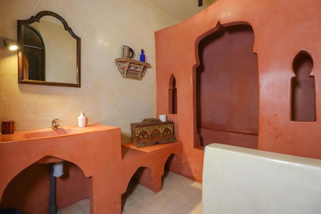 une salle de bains avec lavabo, miroir et baignoire dans l'établissement Riad Salmiya Dune, à Essaouira