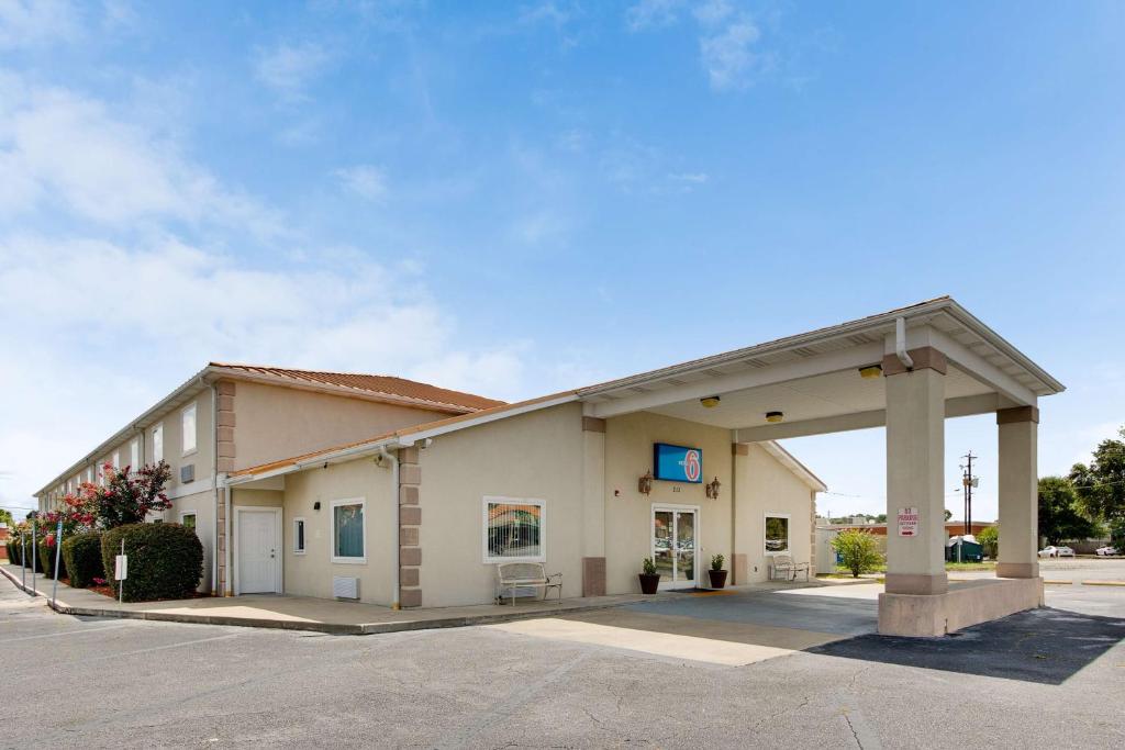 un gran edificio con un cartel en un estacionamiento en Motel 6-Hinesville, GA, en Hinesville