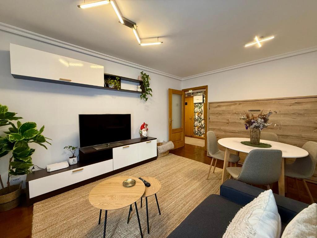 un salon avec une télévision et une table dans l'établissement El Pasaje Apartamento, à Oviedo