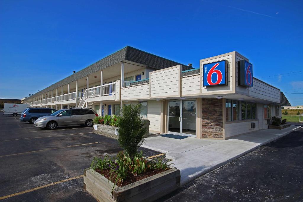 a building with a krispy kreme sign in a parking lot at Motel 6-Lima, OH in Lima