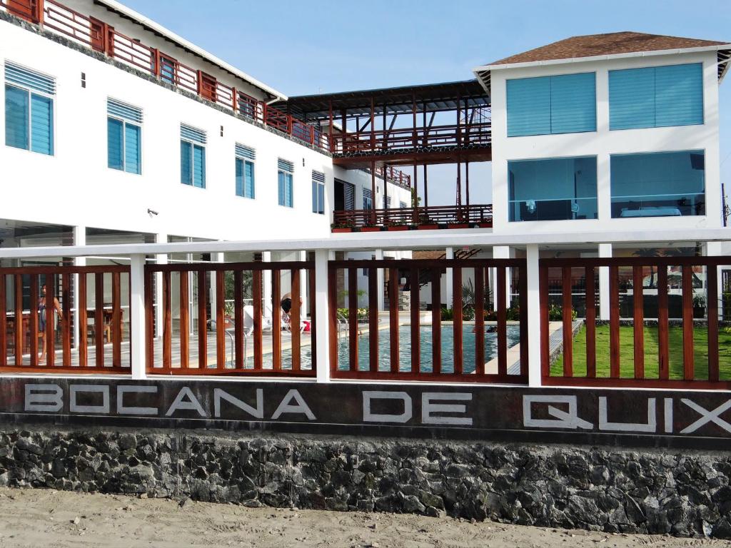 un edificio blanco con un cartel en el costado en La Bocana de Quiximies Hotel, en Cojimíes