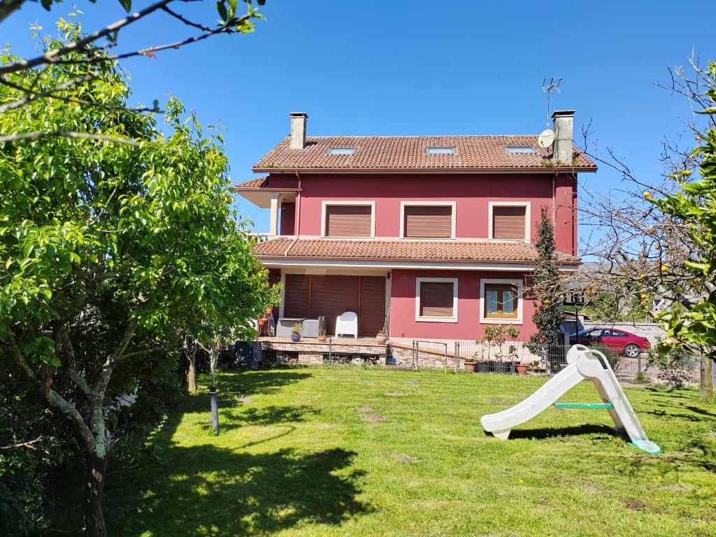 a house with a slide in front of a house at Casa Seán in Boiro