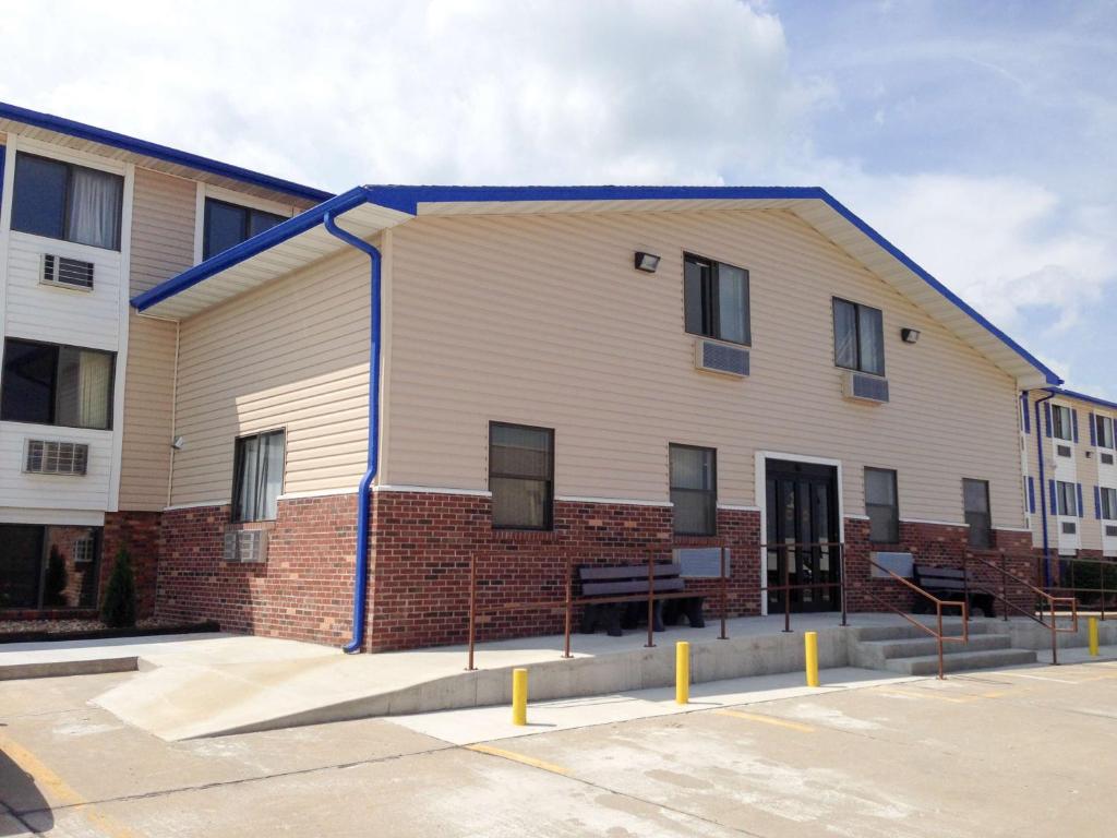 een groot wit gebouw met een blauw dak bij Motel 6-Sedalia, MO in Sedalia