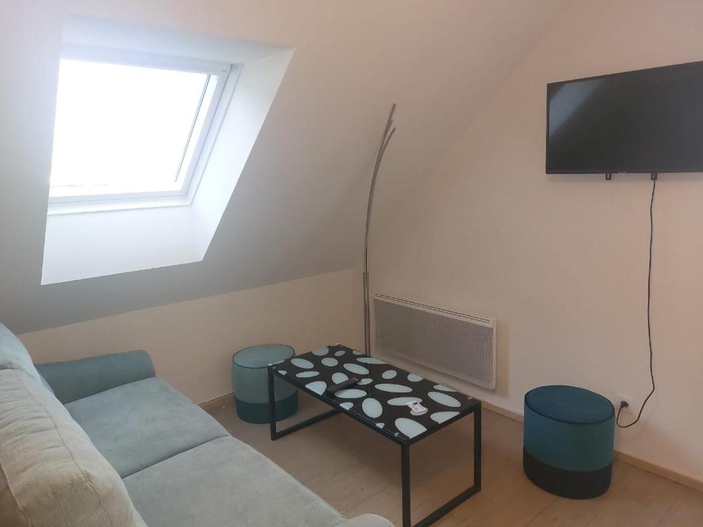 een woonkamer met een bank en een tv bij L'Eclose - Les Korrigans in Le Guilvinec