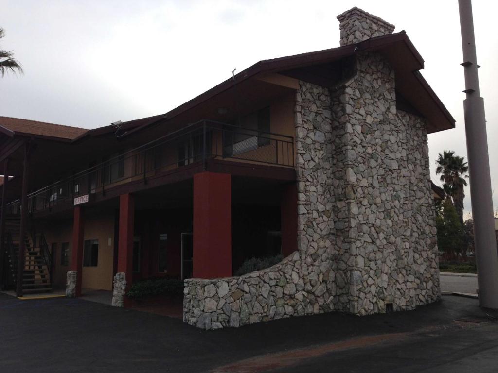 a building with a stone facade with a balcony at Hotel Salina Beaumont CA in Beaumont