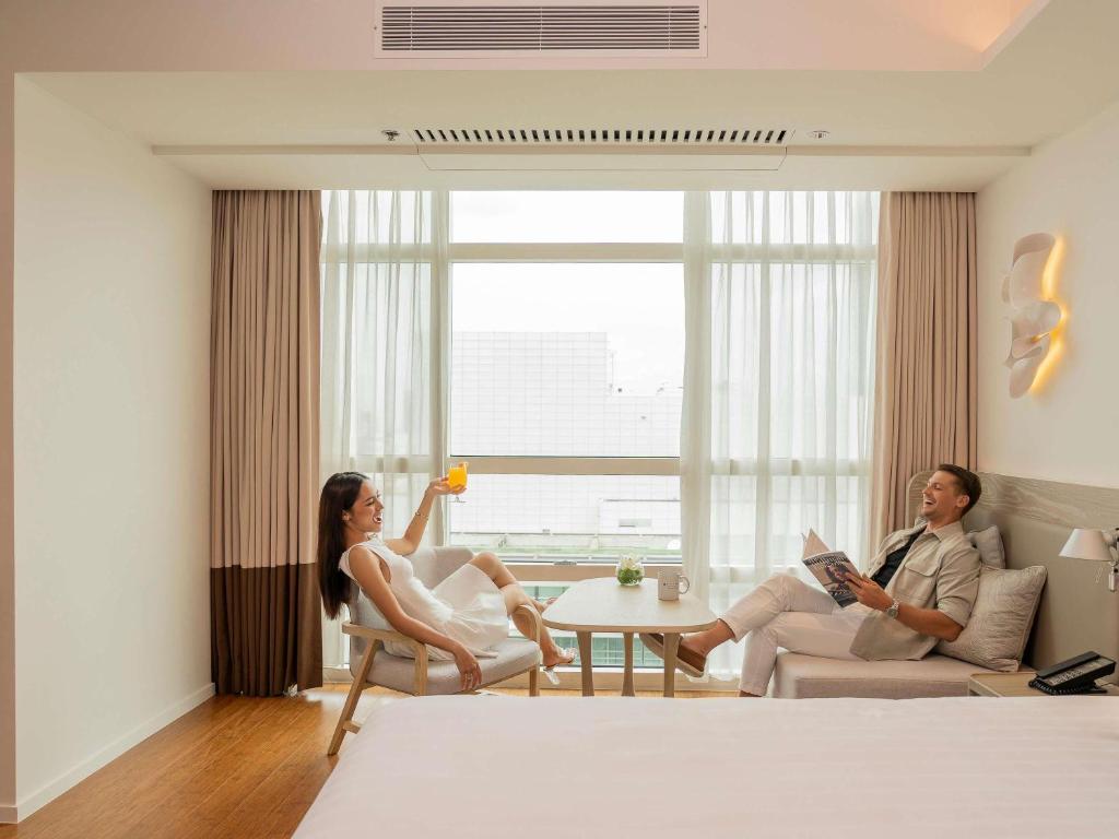 een man en vrouw in een hotelkamer bij Pullman Bangkok King Power in Bangkok