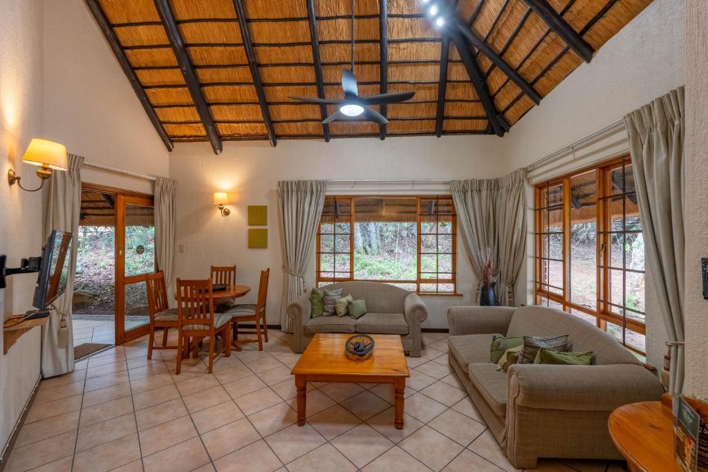 ein Wohnzimmer mit Sofa und Tisch in der Unterkunft Kruger Park Lodge Unit No. 543 in Hazyview