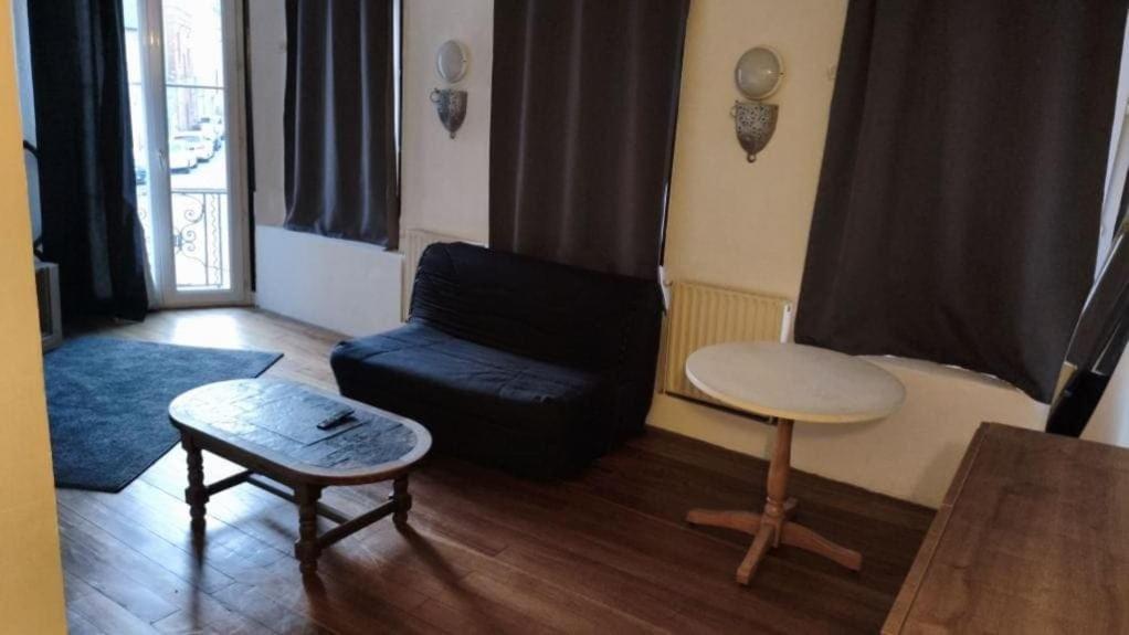a living room with a couch and a table at Harfleur Studio in Harfleur