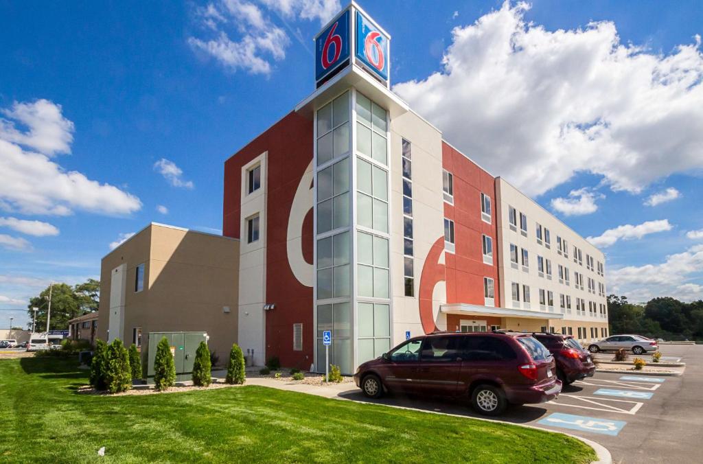 un edificio con una torre de reloj junto a un aparcamiento en Motel 6-South Bend, IN - Mishawaka en South Bend