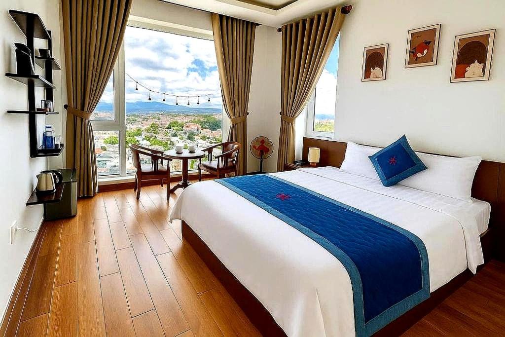 ein Schlafzimmer mit einem Bett und einem Tisch mit Aussicht in der Unterkunft Thu Hiền hotel Gần Chợ có Máy Chiếu in Da Lat