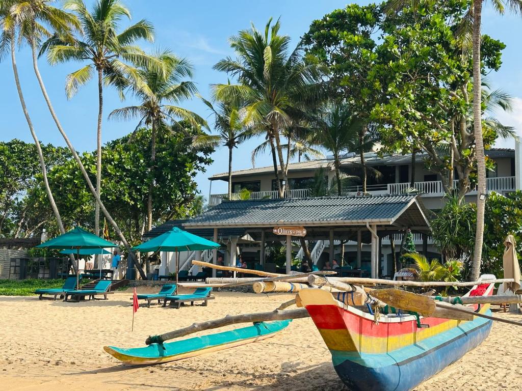 een strand met twee boten op het zand bij Suite Lanka in Hikkaduwa