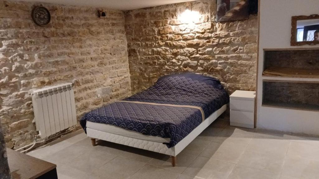 una camera da letto con un letto in un muro di mattoni di Luxury suite lilas 5 a Digione